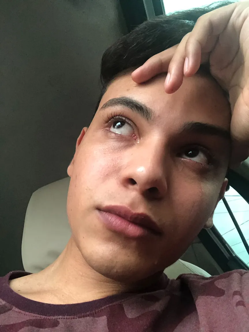 Thiago Hora no banco de um carro, com a mão na testa